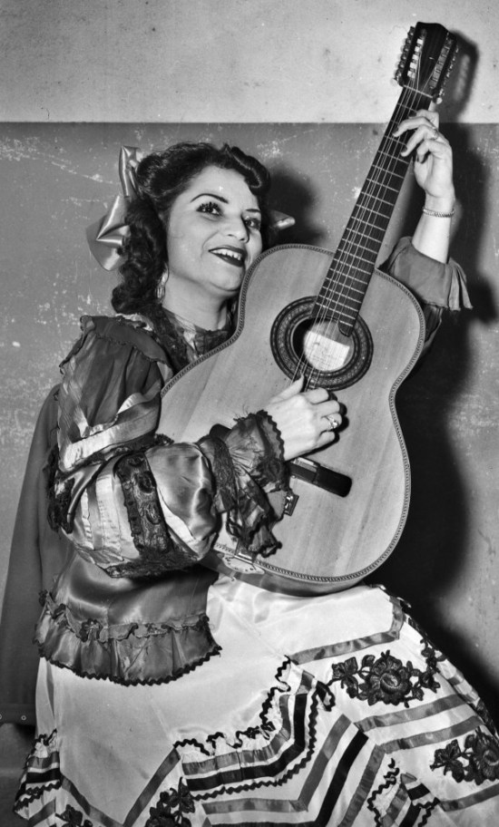 Lydia Mendoza, “The Lark of the Border,” poses with her guitar at the time she was appearing at the Nacional Theater in San Antonio, January 1948.  (MS 359:  L-3514-A).   Mendoza (1916-2007), the first star of recorded Tejano and Norteno music, began singing as a child with her family on the plazas of San Antonio.   She achieved national prominence and was awarded the National Medal of Arts and numerous other awards.